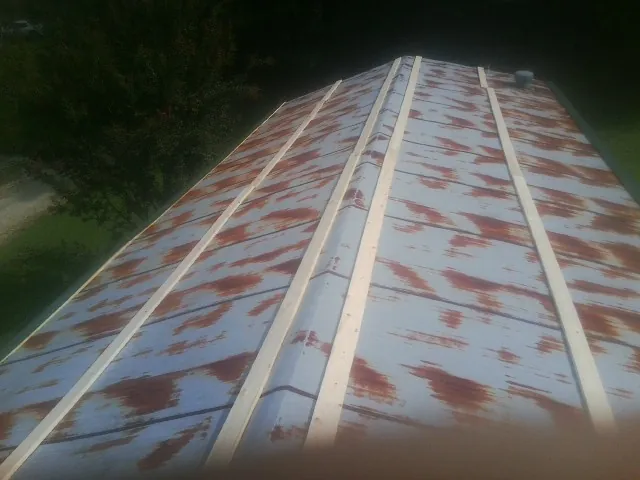 Rusted metal roof panels with new wood purlins before replacement — Storm Damage Roof Repair in Garden Grove by Roofing Brothers